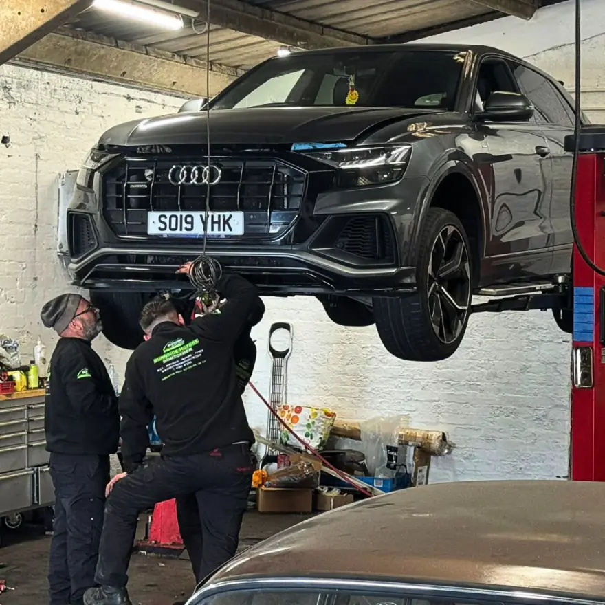 Burnside Motors mechanics working under a car on the two post lift